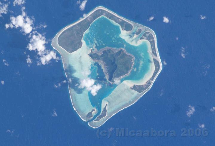 1Maupiti.jpg - Vue arienne de l'le de Maupiti, on distingue parfaitement les zones de faible profondeur, la seule passe praticable, les motu et le massif volcanique.